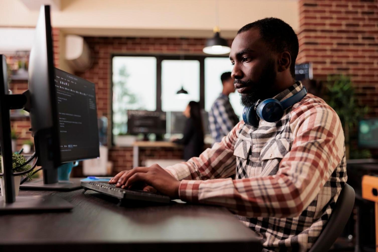 Students debugging mobile game code on multiple devices